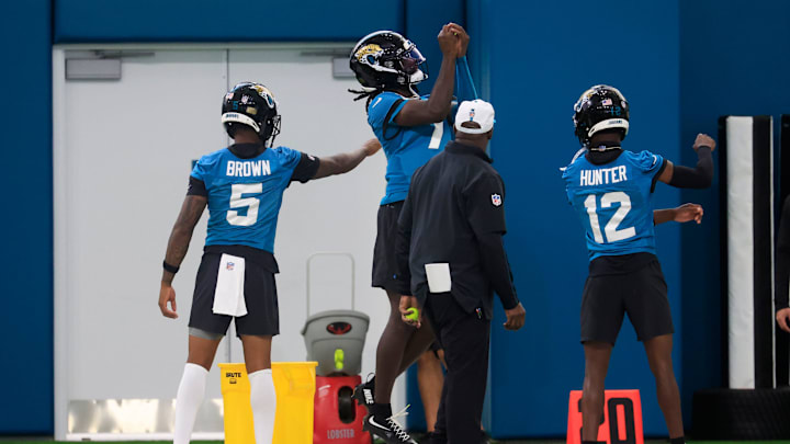 From left, Jacksonville Jaguars wide receiver Dyami Brown (5), wide receiver Brian Thomas Jr. (7) and wide receiver Travis Hunter (12) participate in a reflex exercise with a tennis ball during the 10th organized team activity at Miller Electric Center Wednesday, June 4, 2025 in Jacksonville, Fla. [Corey Perrine/Florida Times-Union]
