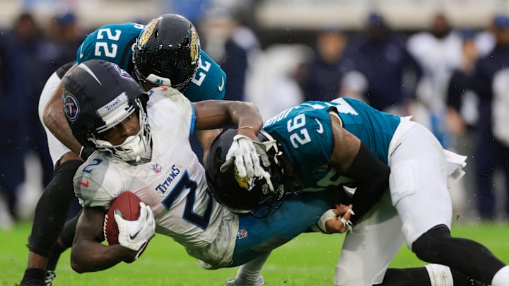 Jacksonville Jaguars cornerback Jarrian Jones (22) and safety Antonio Johnson (26) combine to tackle Tennessee Titans running back Tyjae Spears (2) during the second quarter of an NFL football matchup Sunday, Dec. 29, 2024 at EverBank Stadium in Jacksonville, Fla. [Corey Perrine/Florida Times-Union]