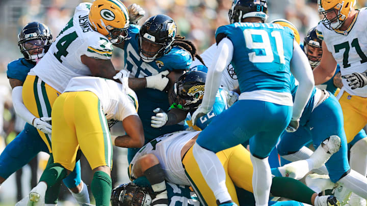 Jacksonville Jaguars defensive tackle Tyler Lacy (93), bottom, reaches for the foot of Green Bay Packers running back Emanuel Wilson (31) as Jacksonville Jaguars defensive tackle DaVon Hamilton (52) tangles with Green Bay Packers guard Elgton Jenkins (74) during the third quarter of an NFL football matchup Sunday, Oct. 27, 2024 at EverBank Stadium in Jacksonville, Fla. The Packers edged the Jaguars 30-27 on a last-second field goal. [Corey Perrine/Florida Times-Union]