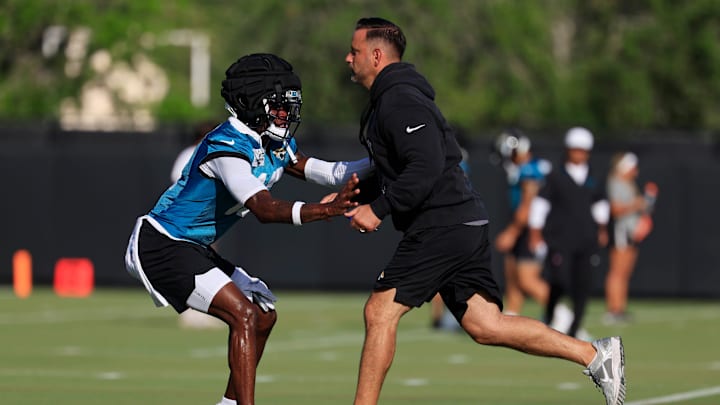 Jacksonville Jaguars wide receiver Travis Hunter (12), left, is pressured by defensive coordinator Anthony Campanile during an NFL training camp session at the Miller Electric Center, Sunday, Aug. 3, 2025, in Jacksonville, Fla. [Corey Perrine/Florida Times-Union]