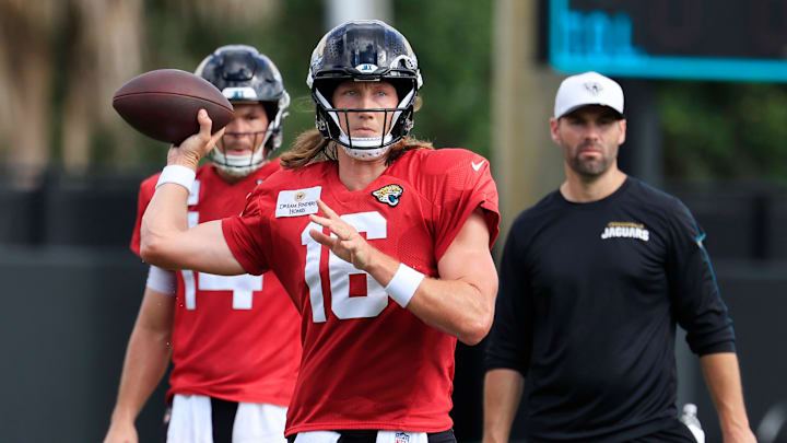 Jacksonville Jaguars quarterback Trevor Lawrence (16) looks to pass as quarterback Nick Mullens (14), left, and quarterbacks coach Spencer Whipple looks on during an NFL training camp session at the Miller Electric Center, Thursday, Aug. 14, 2025 in Jacksonville, Fla.