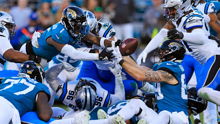 Jacksonville Jaguars running back Travis Etienne Jr. (1) scores a touchdown breaking the plane with tight end Luke Farrell (89), seated, looking on as Carolina Panthers linebacker Frankie Luvu (49), back, and linebacker Yetur Gross-Matos (97), right, can t make the stop during the fourth quarter of a regular season NFL football matchup Sunday, Dec. 31, 2023 at EverBank Stadium in Jacksonville, Fla. The Jacksonville Jaguars blanked the Carolina Panthers 26-0. Jacksonville Jaguars running back Travis Etienne Jr. (1) scores a touchdown breaking the plane with tight end Luke Farrell (89), seated, looking on as Carolina Panthers linebacker Frankie Luvu (49), back, and linebacker Yetur Gross-Matos (97), right, can t make the stop during the fourth quarter of a regular season NFL football matchup Sunday, Dec. 31, 2023 at EverBank Stadium in Jacksonville, Fla. The Jacksonville Jaguars blanked the Carolina Panthers 26-0.