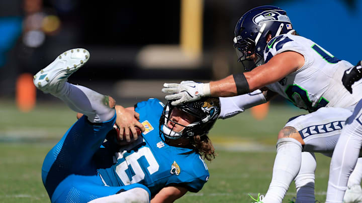 Jacksonville Jaguars quarterback Trevor Lawrence (16) slides for a first down pickup against Seattle Seahawks linebacker Drake Thomas (42) during the fourth quarter of an NFL football matchup, Sunday, Oct. 12, 2025, at EverBank Stadium in Jacksonville, Fla. The Seahawks defeated the Jaguars 20-12. [Corey Perrine/Florida Times-Union]