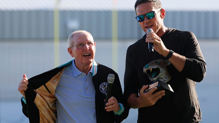 Former Jacksonville Jaguars head coach Tom Coughlin, left, is awarded a trophy for being named to the Jaguar Ring of Honor in 2024, by Executive Vice President of Football Operations Tony Boselli, during an NFL training camp session at the Miller Electric Center, Sunday, Aug. 3, 2025, in Jacksonville, Fla. [Corey Perrine/Florida Times-Union]