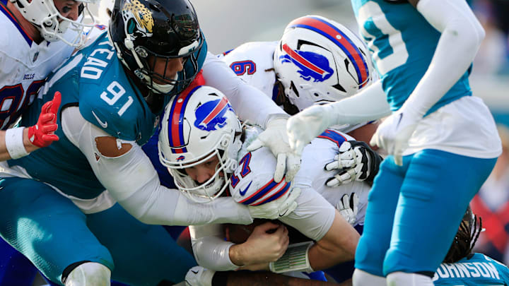 Buffalo Bills quarterback Josh Allen (17) rushes for yards just shy of the goal line as Jacksonville Jaguars defensive tackle Arik Armstead (91) and safety Antonio Johnson (26) combine to make the tackle during the fourth quarter of an NFL football AFC Wild Card playoff matchup, Sunday, Jan. 11, 2026, in Jacksonville, Fla. The Bills defeated the Jaguars 27-24. [Corey Perrine/Florida Times-Union]