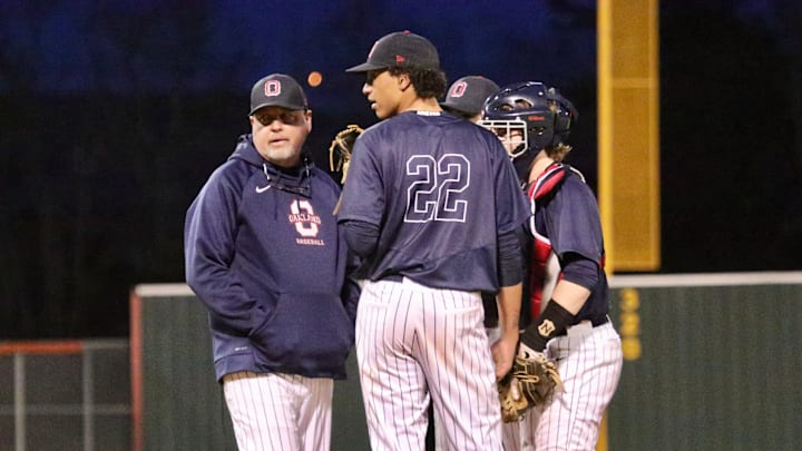 Oakland coach Mack Hawks talks to pitcher Eriq Swan (22) during Monday's season opener. Blackman defeated Oakland 3-2.