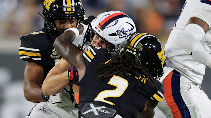 Virginia Cavaliers wide receiver Eli Wood (82) is tackled by Missouri Tigers cornerback Toriano Pride Jr. (2) as safety Jalen Catalon (6) helsp during the first quarter of the TaxSlayer Gator Bowl at EverBank Stadium, Saturday, Dec. 27, 2025, in Jacksonville. Fla. [Corey Perrine/Florida Times-Union]