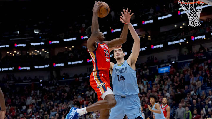 Dec 27, 2024; New Orleans, Louisiana, USA;  New Orleans Pelicans center Yves Missi (21) shoots against Memphis Grizzlies center Zach Edey (14) during the first quarter at Smoothie King Center. Mandatory Credit: Matthew Hinton-Imagn Images