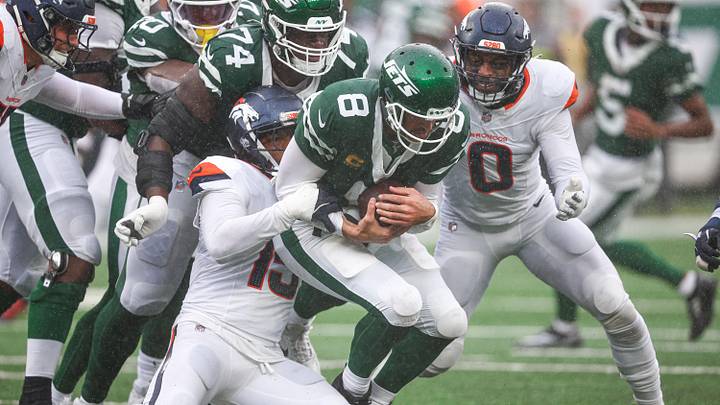 Sep 29, 2024; East Rutherford, New Jersey, USA; New York Jets quarterback Aaron Rodgers (8) is tackled by Denver Broncos linebacker Nik Bonitto (15) and linebacker Jonathon Cooper (0) during the first half at MetLife Stadium. Mandatory Credit: Vincent Carchietta-Imagn Images