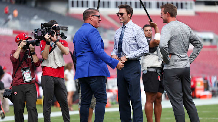 Sep 29, 2024; Tampa, Florida, USA;   Fox NFL broadcaster and former NFL quarterback Tom Brady speaks to Tampa Bay Buccaneers general manager Jason Licht before a game against the Philadelphia Eagles at Raymond James Stadium. Mandatory Credit: Nathan Ray Seebeck-Imagn Images