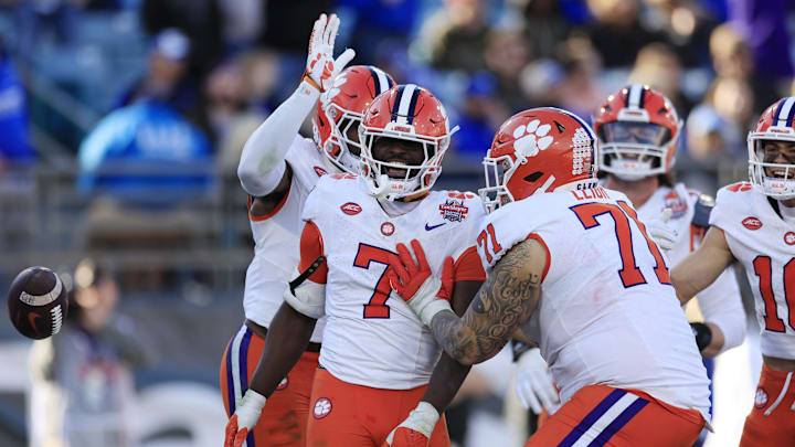 Clemson Tigers running back Phil Mafah (7) is congratulated by wide receiver Adam Randall (8), back, and Clemson Tigers offensive lineman Tristan Leigh (71) after scoring a touchdown during the fourth quarter of an NCAA football matchup in the TaxSlayer Gator Bowl Friday, Dec. 29, 2023 at EverBank Stadium in Jacksonville, Fla. The Clemson Tigers edged the Kentucky Wildcats 38-35. [Corey Perrine/Florida Times-Union]