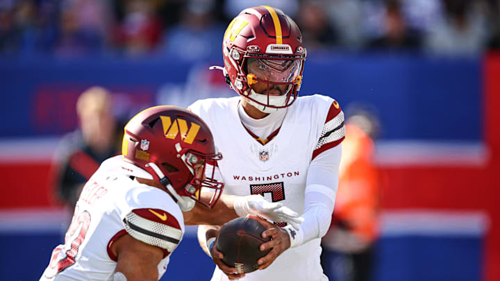 Nov 3, 2024; East Rutherford, New Jersey, USA; Washington Commanders quarterback Jayden Daniels (5) hands off to running back Austin Ekeler (30) during the first half against the New York Giants at MetLife Stadium. Mandatory Credit: Vincent Carchietta-Imagn Images