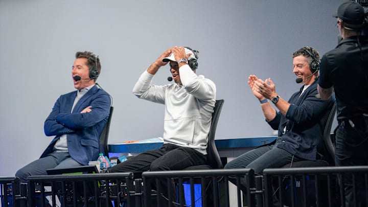 ESPN announcer Matt Barrie, Tiger Woods and Rory McIlroy react to a putt made during the inaugural TGL match at SoFi Center.