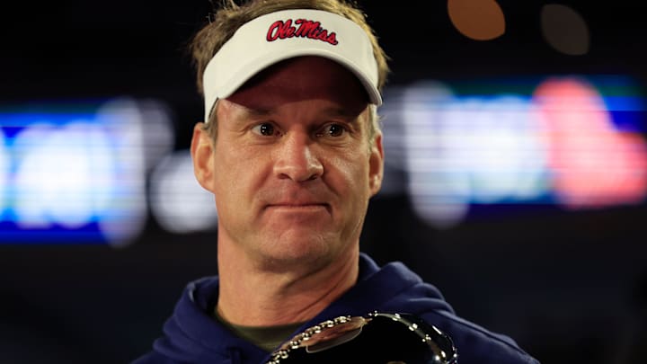 Jan. 2, 2024: Rebels head coach Lane Kiffin holds the Ash Verlander Champions Trophy after defeating the Duke Blue Devils in the Gator Bowl.