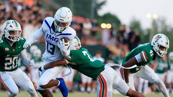 IMG Academy's Osani Gayles (13) rushes for yards against Mandarin's Tamajh Mitchell (7) during the first quarter of a high school football matchup at Mandarin High School, Friday, Sept. 19, 2025, in Jacksonville, Fla. The IMG Academy Ascenders defeated the Mandarin Mustangs 57-7.