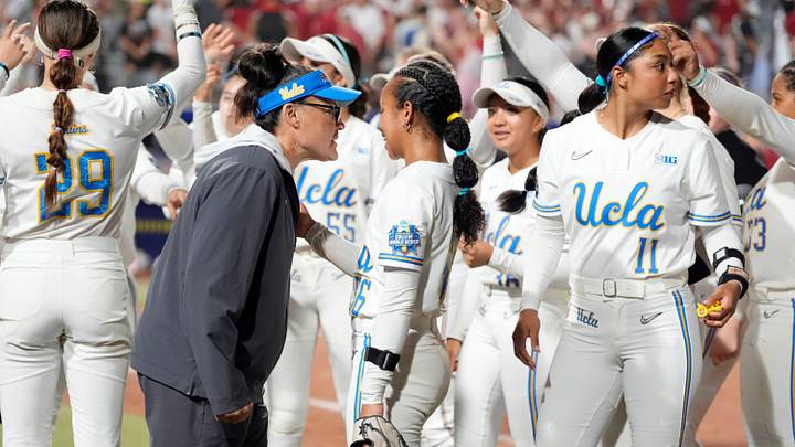 UCLA Bruins head coach Kelly Inouye-Perez talks with UCLA Bruins utility Mia Phillips (56) during a Women's College World Series softball game between the UCLA Bruins and the Arkansas Razorbacks at Devon Park in Oklahoma City, Friday, May 29, 2026.