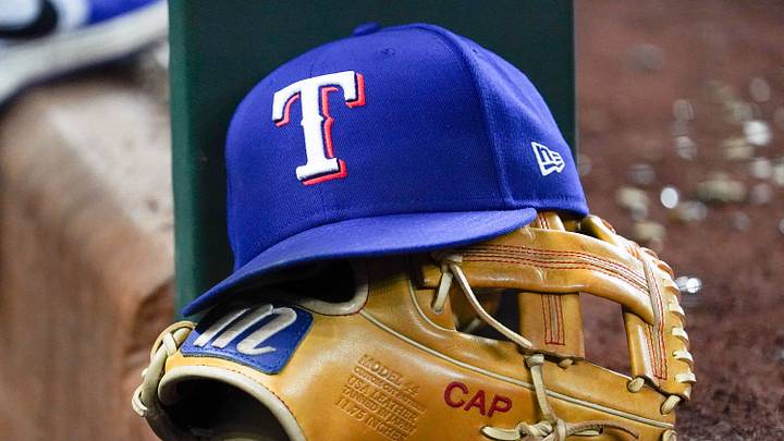 Apr 28, 2025; Arlington, Texas, USA; A Texas Rangers cap and baseball mitt sit on the dugout steps during a game against the Athletics at Globe Life Field. Mandatory Credit: Raymond Carlin III-Imagn Images