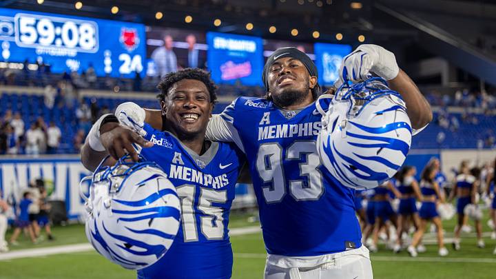 Memphis Tigers defensive lineman Elijah Kinsler (15) and defensive lineman Jabari Ishmael (93) react after winning the game against Arkansas State at Simmons Bank Liberty Stadium. Mandatory Credit: Wesley Hale-Imagn Images Memphis Tigers defensive lineman Elijah Kinsler (15) and defensive lineman Jabari Ishmael (93) react after winning the game against Arkansas State at Simmons Bank Liberty Stadium. Mandatory Credit: Wesley Hale-Imagn Images