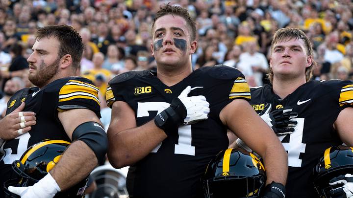 Iowa Hawkeyes offensive lineman Jack Dotzler (71), center, stands with teammates as the national anthem plays ahead of the Cy-Hawk football game Sept. 12, 2026 at Kinnick Stadium in Iowa City, Iowa. Iowa Hawkeyes offensive lineman Jack Dotzler (71), center, stands with teammates as the national anthem plays ahead of the Cy-Hawk football game Sept. 12, 2026 at Kinnick Stadium in Iowa City, Iowa.