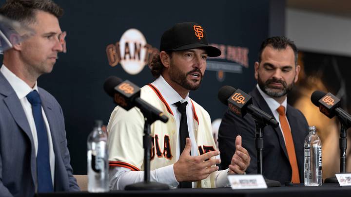 Oct 30, 2025; San Francisco, CA, USA;  Tony Vitello (center) answers questions from the media as he is introduced as the new manager of the San Francisco Giants at Oracle Park. He is flanked by president of baseball operations Buster Posey (left) and general manager Zack Minasian. Mandatory Credit: D. Ross Cameron-Imagn Images