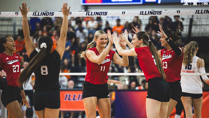 Nebraska volleyball players celebrate a point at Illinois.