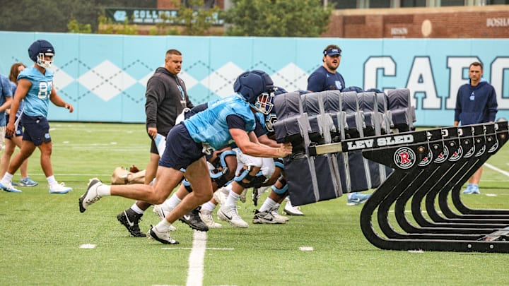 North Carolina players pushing the blocking shed during practice at the Koman Practice Complex on Aug. 2 
