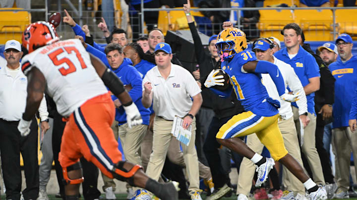 Oct 24, 2024; Pittsburgh, Pennsylvania, USA; Pittsburgh Panthers linebacker Rasheem Biles (31) returns an interception for a touchdown while being chased by Syracuse Orange offensive lineman Da'Metrius Weatherspoon (57) during the first quarter  at Acrisure Stadium. Mandatory Credit: Barry Reeger-Imagn Images