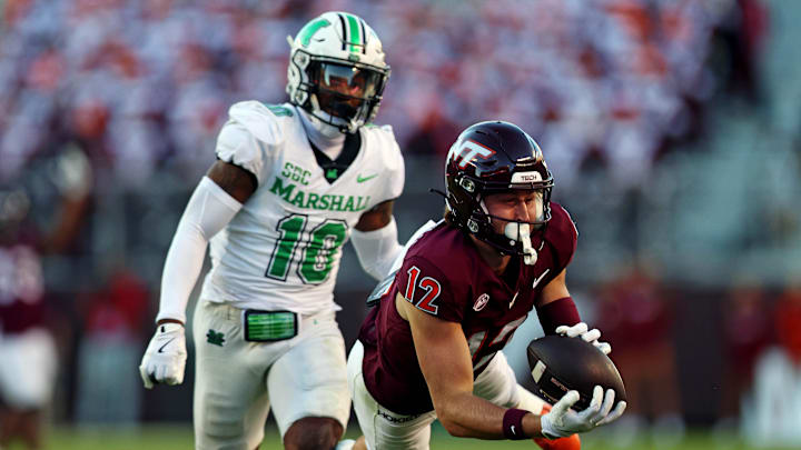 Sep 7, 2024; Blacksburg, Virginia, USA; Virginia Tech Hokies wide receiver Stephen Gosnell (12) dives for a catch against Marshall Thundering Herd cornerback Jacobie Henderson (10) during the second quarter at Lane Stadium. Mandatory Credit: Peter Casey-Imagn Images