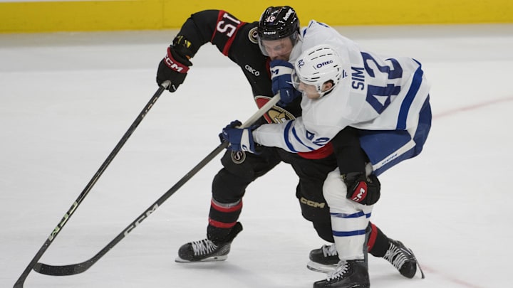 Sep 21st, 2025; Ottawa, Ontario, CAN; Ottawa Senators left wing Olle Lycksell (15) battles with Toronto Maple Leafs left wing Landon Sim (42) for control of the puck in the third period at the Canadian Tire Centre. Mandatory Credit: Marc DesRosiers-IMAGN Images