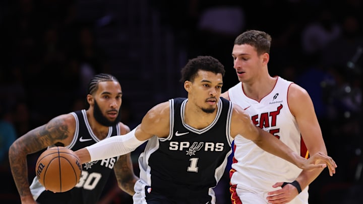 Oct 15, 2024; Miami, Florida, USA; San Antonio Spurs center Victor Wembanyama (1) dribbles the basketball past Miami Heat forward Nikola Jovic (5) during the first quarter at Kaseya Center. Mandatory Credit: Sam Navarro-Imagn Images