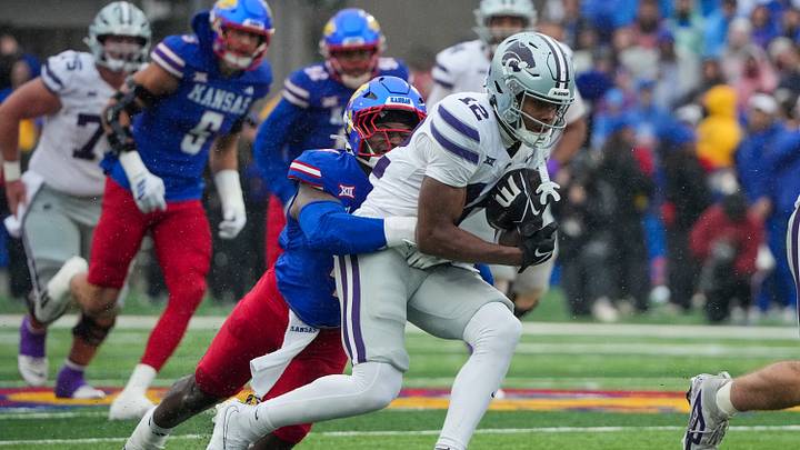 Oct 25, 2025; Lawrence, Kansas, USA; Kansas State Wildcats wide receiver Jaron Tibbs (12) runs the ball as Kansas Jayhawks linebacker Trey Lathan (4) makes the tackle during the first half of the game at David Booth Kansas Memorial Stadium. Mandatory Credit: Denny Medley-Imagn Images Oct 25, 2025; Lawrence, Kansas, USA; Kansas State Wildcats wide receiver Jaron Tibbs (12) runs the ball as Kansas Jayhawks linebacker Trey Lathan (4) makes the tackle during the first half of the game at David Booth Kansas Memorial Stadium. Mandatory Credit: Denny Medley-Imagn Images