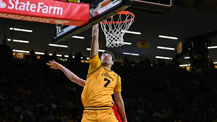 Feb 25, 2026; Iowa City, Iowa, USA; Iowa Hawkeyes forward Alvaro Folgueiras (7) goes to the basket as Ohio State Buckeyes forward Colin White (20) defends during the second half at Carver-Hawkeye Arena. Mandatory Credit: Jeffrey Becker-Imagn Images