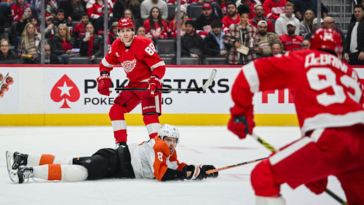 Dec 18, 2024; Detroit, Michigan, USA; Detroit Red Wings right wing Patrick Kane (88) makes an assist to right wing Alex DeBrincat (93) as Philadelphia Flyers defenseman Cam York (8) attempts to defend during the second period at Little Caesars Arena.