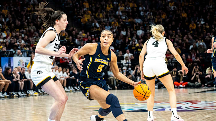 Michigan guard Laila Phelia (5) drives to the basket Iowa guard Caitlin Clark (22) during the Big