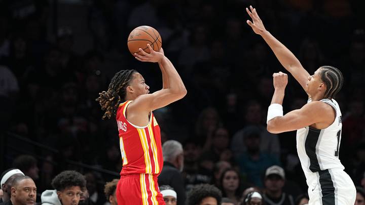 Oct 8, 2026; San Antonio, Texas, USA; Atlanta Hawks guard Kingston Flemings (4) shoots over San Antonio Spurs forward Carter Bryant (11) ahead of Hawks head coach Quin Snyder during the first half at Frost Bank Center. Mandatory Credit: Scott Wachter-Imagn Images Oct 8, 2026; San Antonio, Texas, USA; Atlanta Hawks guard Kingston Flemings (4) shoots over San Antonio Spurs forward Carter Bryant (11) ahead of Hawks head coach Quin Snyder during the first half at Frost Bank Center. Mandatory Credit: Scott Wachter-Imagn Images