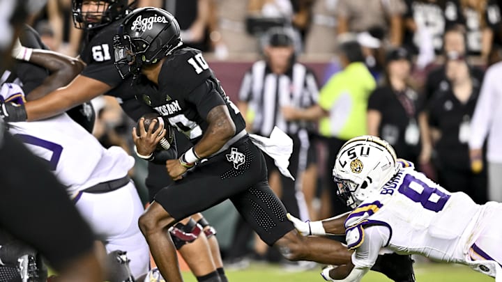 Oct 26, 2024; College Station, Texas, USA; Texas A&M Aggies quarterback Marcel Reed (10) runs the ball in the fourth quarter as LSU Tigers safety Major Burns (8) lunges to attempt a tackle at Kyle Field. Mandatory Credit: Maria Lysaker-Imagn Images. 
