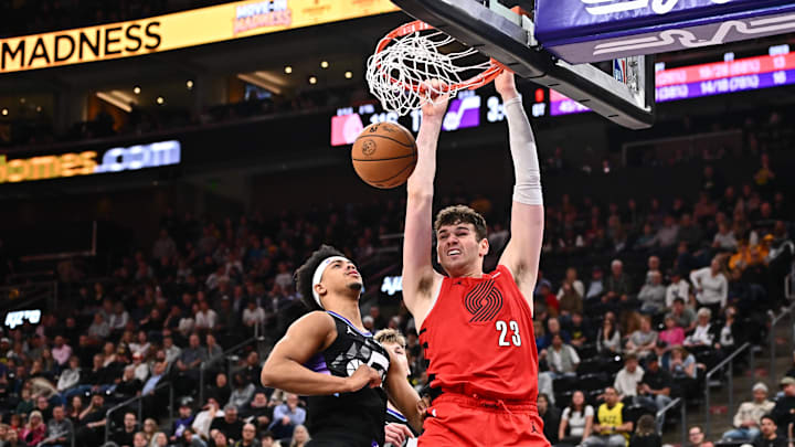 Apr 9, 2025; Salt Lake City, Utah, USA;  Portland Trail Blazers center Donovan Clingan (23) dunks over Utah Jazz guard Jaden Springer (11) in the second half at Delta Center. Mandatory Credit: Jamie Sabau-Imagn Images