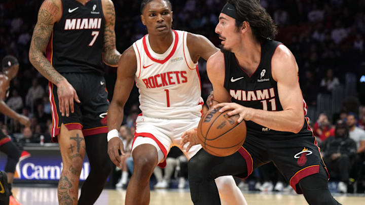 Mar 21, 2025; Miami, Florida, USA;  Miami Heat guard Jaime Jaquez Jr. (11) grabs a rebound as Houston Rockets forward Amen Thompson (1) defends at Kaseya Center. Mandatory Credit: Jim Rassol-Imagn Images