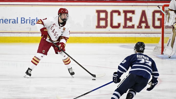 Feb 28, 2025; Chestnut Hill, MA, USA; Boston College defenseman Lukas Gustafsson (8) controls the puck against New Hampshire forward Jason Siedem (23) during the first period at Conte Forum. Mandatory Credit: Eric Canha-Imagn Images