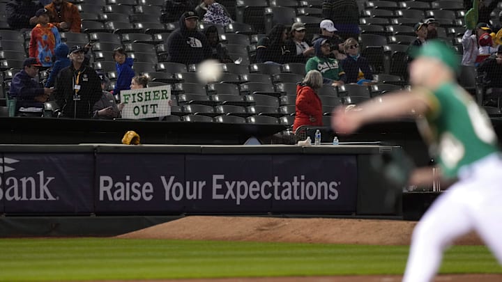 May 12, 2023; Oakland, California, USA; A Oakland Athletics fan holds up a sign directed at owner