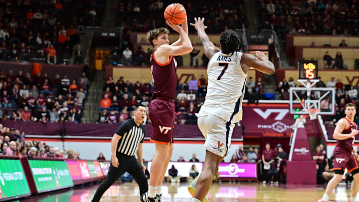 Feb 15, 2025; Blacksburg, Virginia, USA; Virginia Tech Hokies guard Jaden Schutt (2) shoots the ball as Virginia Cavaliers guard Dai Dai Ames (7) defends during the first half at Cassell Coliseum. Mandatory Credit: Brian Bishop-Imagn Images