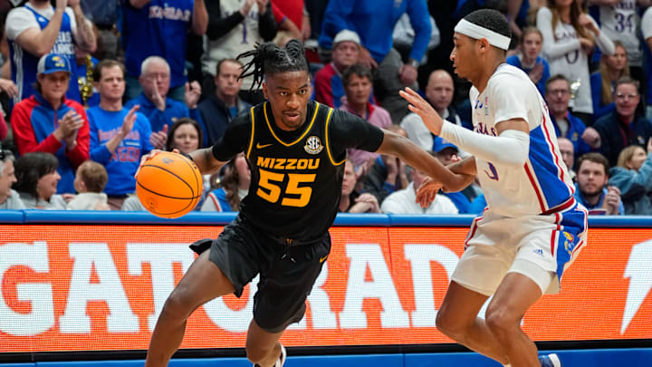 Dec 9, 2023; Lawrence, Kansas, USA; Missouri Tigers guard Sean East II (55) drives against Kansas Jayhawks guard Dajuan Harris Jr. (3) during the first half at Allen Fieldhouse. Mandatory Credit: Jay Biggerstaff-Imagn Images