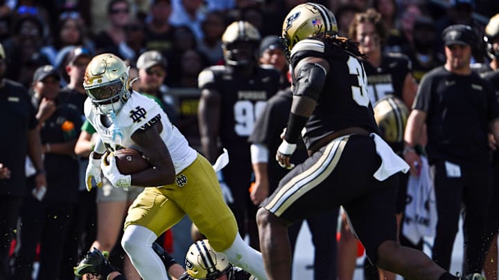 Sep 14, 2024; West Lafayette, Indiana, USA; Notre Dame Fighting Irish tight end Charlie Selna (89) runs the ball against Purdue Boilermakers defensive back Dillon Thieneman (31) and defensive lineman Damarjhe Lewis (34) during the first quarter at Ross-Ade Stadium.