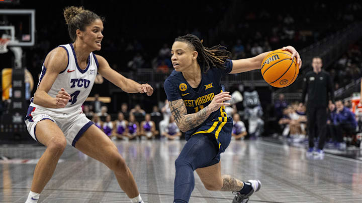 Mar 8, 2025; Kansas City, MO, USA; West Virginia Mountaineers guard JJ Quinerly (11) handles the ball while defended by TCU Horned Frogs guard Donovyn Hunter (4) during the second half at T-Mobile Center. Mandatory Credit: Amy Kontras-Imagn Images