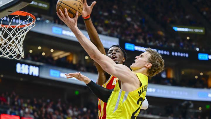 Feb 3, 2023; Salt Lake City, Utah, USA; Utah Jazz forward/center Lauri Markkanen (23) takes a layup around Atlanta Hawks forward/center Onyeka Okongwu (17) during the second half at Vivint Arena. Mandatory Credit: Christopher Creveling-USA TODAY Sports