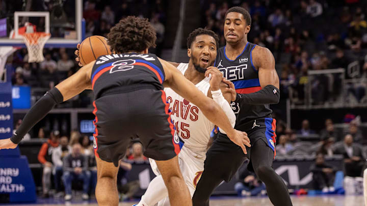 Dec 2, 2023; Detroit, Michigan, USA; Cleveland Cavaliers guard Donovan Mitchell (45) drives the ball into Cade Cunningham and Jaden Ivey of the Detroit Pistons