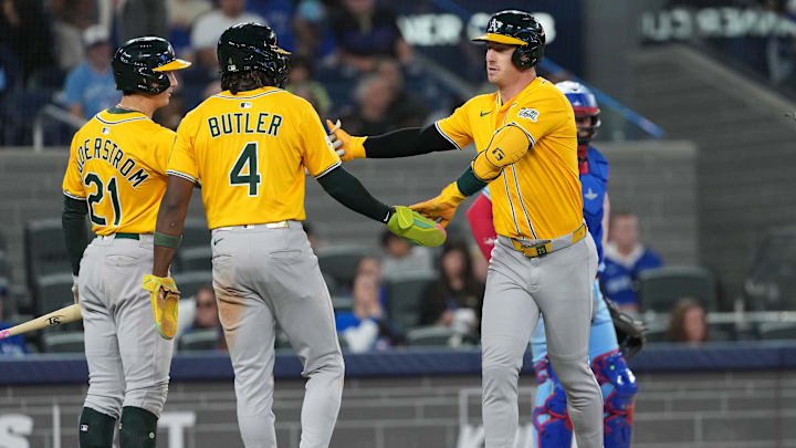 May 31, 2025; Toronto, Ontario, CAN; Athletics designated hitter Brent Rooker (25) hits a two run home run and celebrates with right fielder Lawrence Butler (4) against the Toronto Blue Jays during the ninth inning at Rogers Centre. Mandatory Credit: Nick Turchiaro-Imagn Images