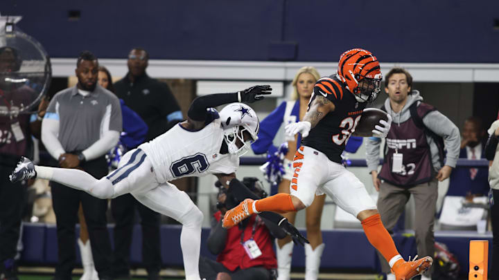 Dec 9, 2024; Arlington, Texas, USA; Cincinnati Bengals cornerback DJ Turner II (20) scores a touchdown against Dallas Cowboys safety Donovan Wilson (6) in the second quarter at AT&T Stadium. Mandatory Credit: Tim Heitman-Imagn Images