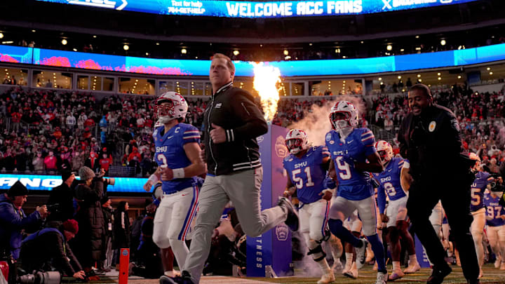 Dec 7, 2024; Charlotte, NC, USA; Southern Methodist Mustangs head coach Rhett Lashlee leads his team to the field before the 2024 ACC Championship game against the Clemson Tigers at Bank of America Stadium. 