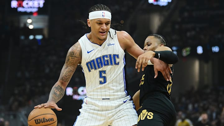 May 5, 2024; Cleveland, Ohio, USA; Orlando Magic forward Paolo Banchero (5) drives to the basket against Cleveland Cavaliers forward Isaac Okoro (35) during the first quarter of game seven of the first round for the 2024 NBA playoffs at Rocket Mortgage FieldHouse. Mandatory Credit: Ken Blaze-Imagn Images